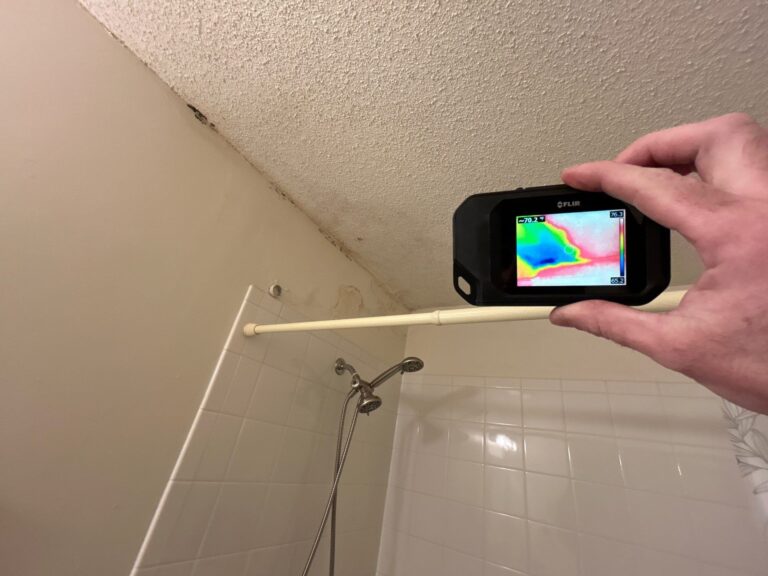 Thermal camera checking a stained bathroom ceiling for hidden moisture and mold